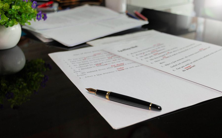 A desk with papers and a pen on it.