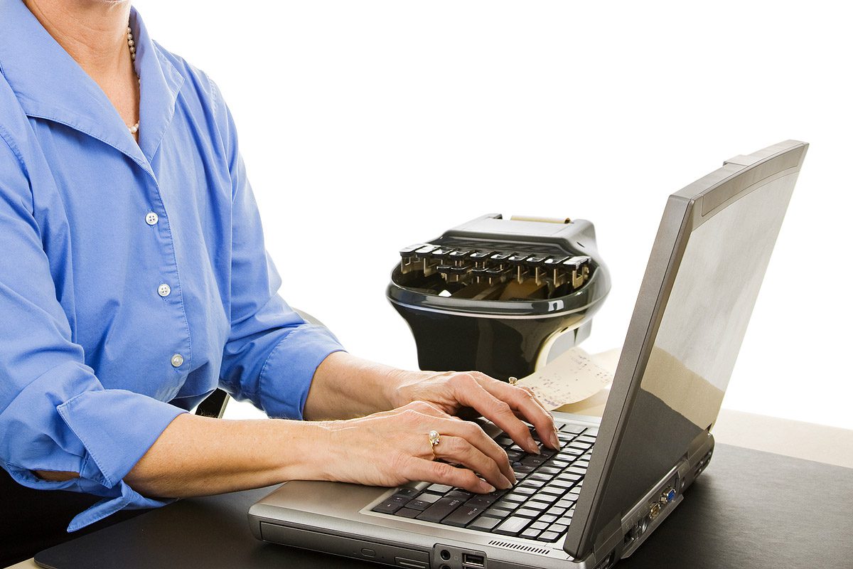 A woman typing on a laptop computer.